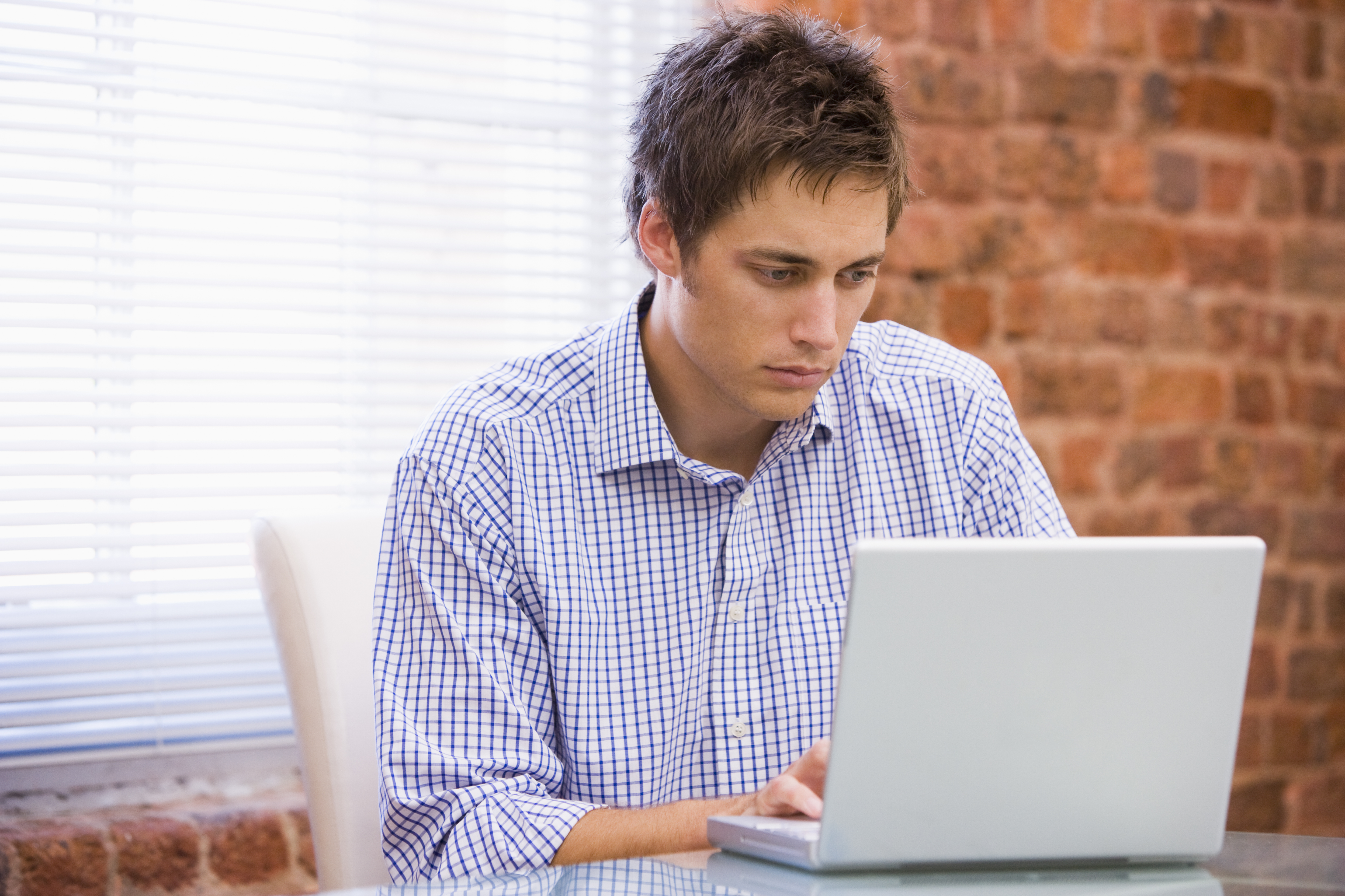 Businessman in office typing on laptop