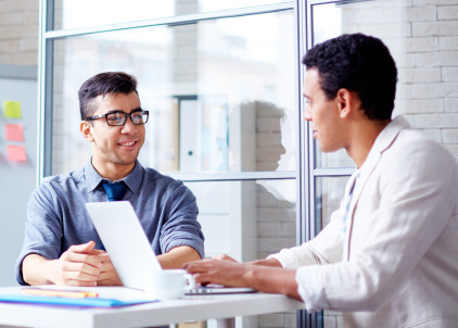 Two young businessmen sharing ideas or discussing project